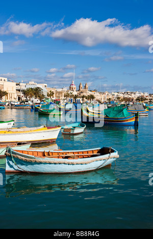 Traditional Maltese fishing boats, called Luzzu, in front of the Church of Our Lady of Pompeii, port of Marsaxlokk, Malta, Euro Stock Photo