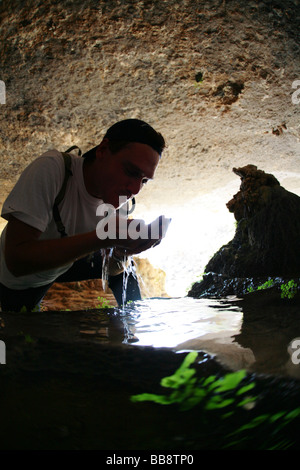 Drinking fresh water in a cave near the deserted village of Sab Bani Khamis in Jebel Shams in Oman Stock Photo