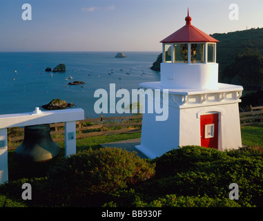 Humbolt County CA: Trinidad Memorial Lighthouse stands above small boats harbored in Trinidad Bay Stock Photo
