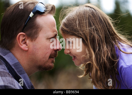 Happy young girl starring each other playfully with her father Stock Photo