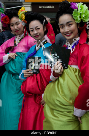 Three colourful Eastern asian female performers promote their show production Edinburgh Fringe Festival Scotland UK Europe Stock Photo