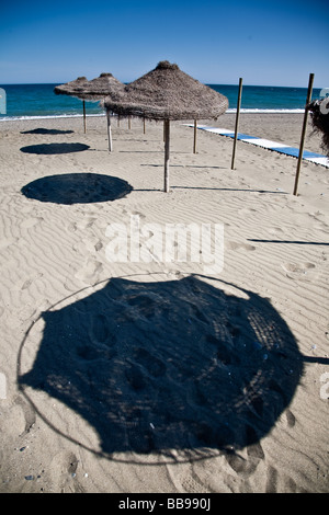 Beach Shades on Cancelada beach Estapona Spain These are permantly errected Straw Beach Umbrellas Stock Photo