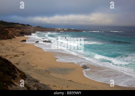 Garrapata State Park CA Light breaking through morning cloud cover onto beach and breaking waves Stock Photo