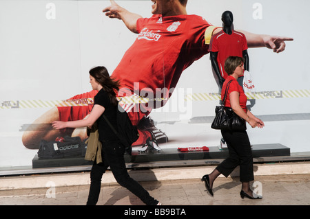 Pedestrians walk past a giant Carlsberg advertisement poster in Sarajevo capital of Bosnia and Herzegovina Stock Photo