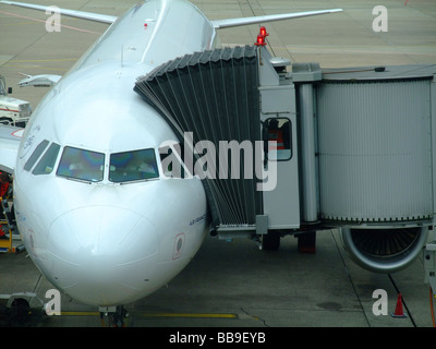 Airbus A320 plane on tarmac with boarding bridge at Dusseldorf International airport