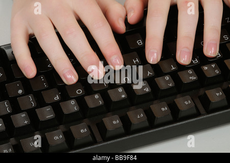 Hands and fingers typing on a computer keyboard Stock Photo