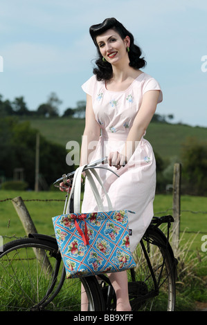 Woman wearing vintage clothing on an old bicycle Stock Photo