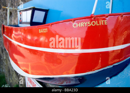 A bright and colourful collection box in the form of a fishing boat mounted on Dunure harbour wall on the West coast of Scotland Stock Photo