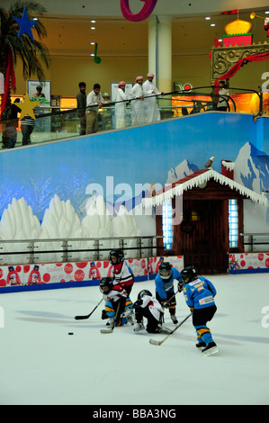 Arabs in Dishdashas, the typical white garments, watching kids playing ice hockey on the ice rink of the Al Ain Mall, Al Ain, A Stock Photo