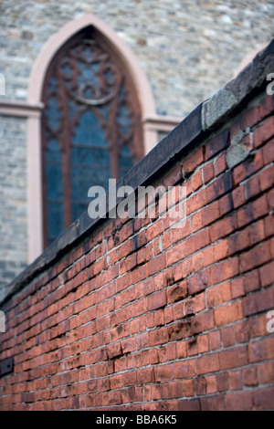 An old brick wall surrounding a church. Stock Photo