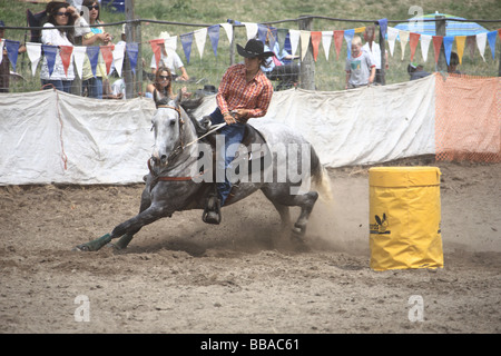 Cowgirl riding in barrel race at rodeo Stock Photo