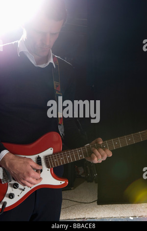 A man playing an electric guitar on stage Stock Photo