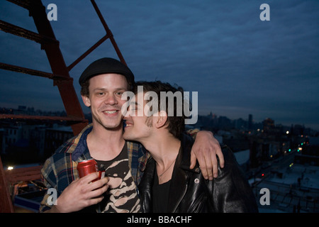 A young couple embracing on a fire escape Stock Photo