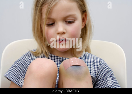 A young girl with a adhesive bandage on her knee Stock Photo