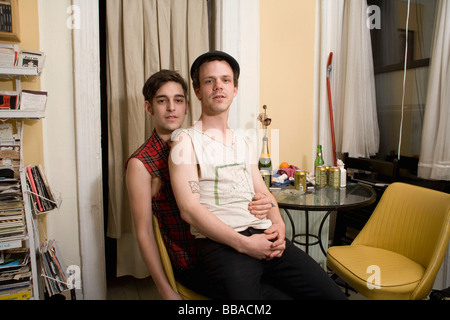 A young couple sitting together by a table Stock Photo