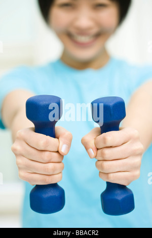 A woman holding two dumbbells Stock Photo