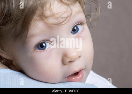 A young boy being held, over the shoulder view Stock Photo