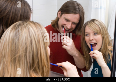 A young couple brushing their teeth together Stock Photo