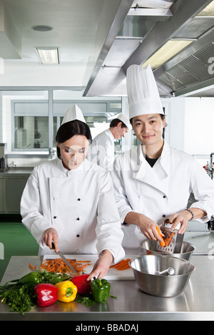 Two chefs doing prep work in a commercial kitchen Stock Photo