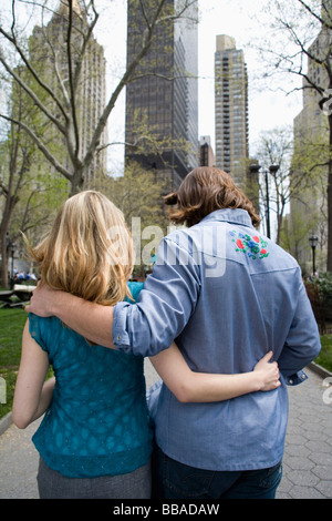 A young couple walking arm in arm through a city park, Central Park, New York City Stock Photo