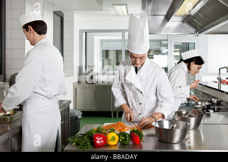 Three chefs working in a commercial kitchen Stock Photo