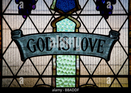 God Is Love written in a stained glass window Stock Photo
