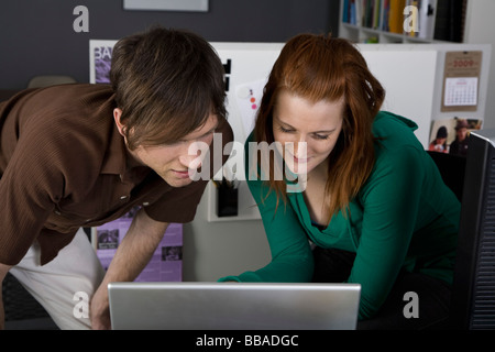 A businessman and businesswoman looking at a laptop Stock Photo