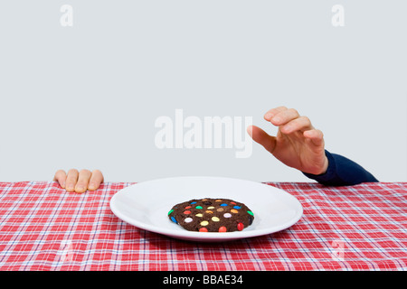 A hand reaching for a cookie Stock Photo