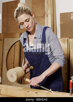 A woman chiseling wood Stock Photo