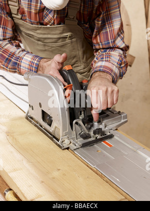Detail of a man cutting wood with a rotary saw Stock Photo