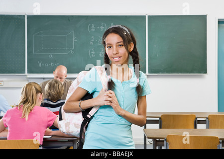 Portrait of a schoolgirl standing in a classroom Stock Photo