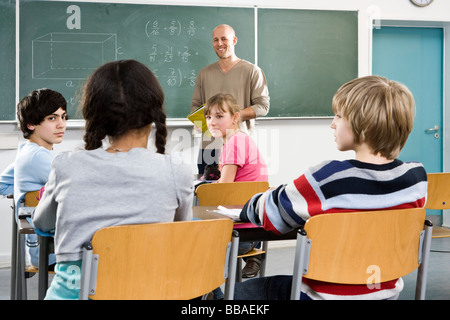 Students and a teacher in a classroom Stock Photo