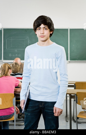 Portrait of a schoolboy standing in a classroom Stock Photo