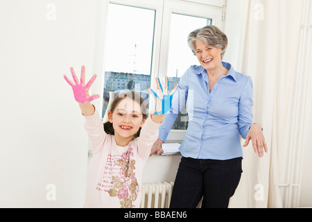 A grandmother and her granddaughter finger painting Stock Photo
