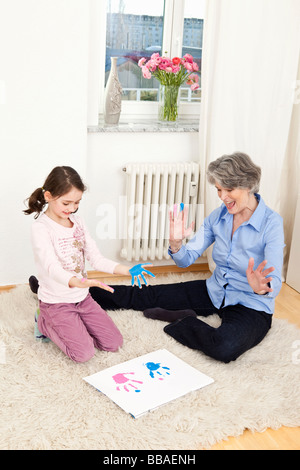 A grandmother and her granddaughter finger painting Stock Photo