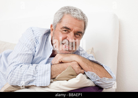 A senior man lying on a couch Stock Photo