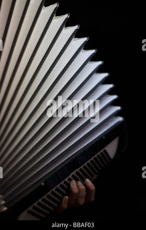 A human hand playing an accordion Stock Photo