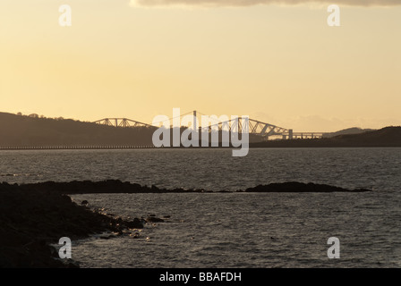 Forth road and rail bridge at dusk from Granton Harbour, Leith, Edinbugh, Scotland with rocks in the foreground Stock Photo