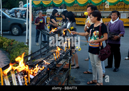 Thai people lighting up incense sticks in a buddhist temple of Chiang Mai, Thailand Stock Photo