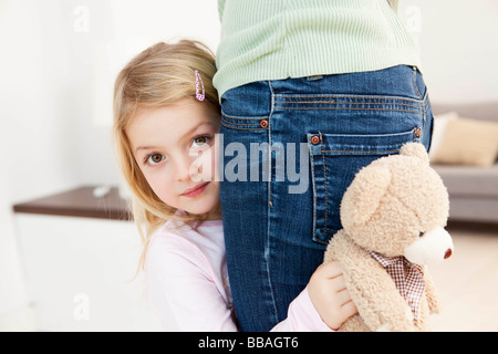 daughter hiding behind mother Stock Photo