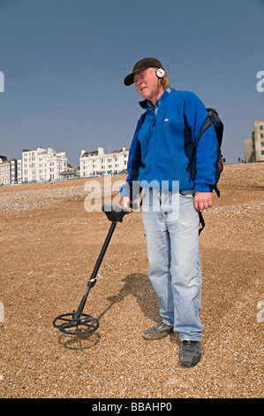 a metal detecting man on brighton beach trying to find money Stock Photo