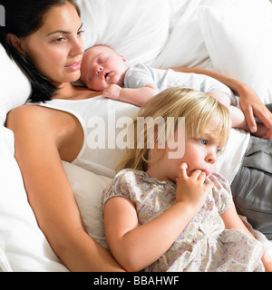 Mother with babies in bed Stock Photo