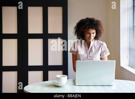 Woman in cafe working on laptop Stock Photo