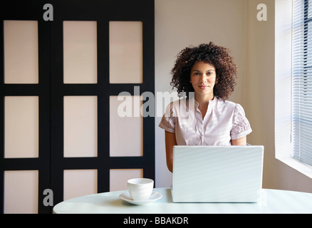 Woman in cafe working on laptop Stock Photo