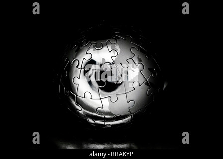 Metal earth jigsaw against blackness Stock Photo
