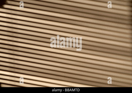 shadow cast from a window and strong sunlight falling on a wall through a venetian blind Stock Photo