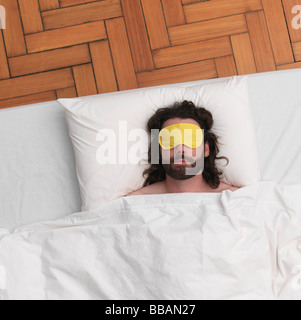 Man sleeping, wearing eye-mask Stock Photo