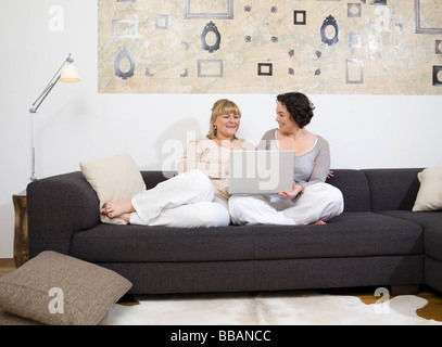 Two women chatting on the couch. Stock Photo