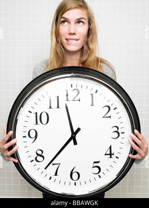 Woman holding a big clock Stock Photo