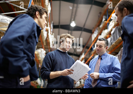Manager and workers in warehouse Stock Photo